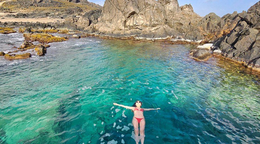 Swimmer in a natural pool on Aruba’s rocky north coast